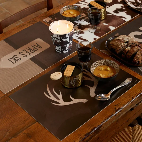 Un set de table vinyle pratique, durable et tendance pour une table impeccable Ajoutez une touche de charme montagnard à votre table avec nos sets de table en vinyle au look montagnard. Inspirés par les paysages majestueux des montagnes, ces sets de table évoquent une ambiance rustique et chaleureuse tout en protégeant vos surfaces des éclaboussures et des rayures. Fabriqués en vinyle de haute qualité, ils offrent une combinaison parfaite de style et de fonctionnalité pour des repas en toute tranquillité. Nos sets de table au look montagnard se distinguent par leurs motifs inspirés de la nature alpine, tels que des motifs de flocons de neige, des arbres de conifères et des chalets en bois. Disponibles dans une variété de designs rustiques et authentiques, ils créent une atmosphère confortable et accueillante à votre table. Que vous organisiez un dîner après une journée de ski, un brunch en famille ou une soirée entre amis, ces sets de table ajoutent une touche de convivialité à chaque repas. Polyvalents et pratiques, nos sets de table en vinyle sont conçus pour résister à une utilisation quotidienne. Leur surface lisse et antidérapante assure que les assiettes et les verres restent en place, tandis que leur matériau durable se nettoie facilement avec un simple coup d'éponge. Offrez à votre table une ambiance montagnarde avec nos sets de table en vinyle au look montagnard, et profitez de chaque repas dans le confort de votre propre refuge alpin. Composition Un set de table vinyle 100% fabriqué en France ­­­­­­PVC imprimés et découpés. Épaisseur 2,4 mm. Vernis protecteur mat anti-UV et de haute flexibilité. Résistance extérieure. Norme REACH et jouets, classement au feu, 100% recyclable, 0% phtalate. Excellente planéité et bonne stabilité dimensionnelle. Isolation sonore. Résistance accrue contre l’abrasion. Entretien Utilisez une éponge magique, c’est fantastique ! Convient au lave-vaisselle.